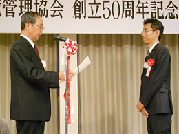 産業環境管理協会　冨澤龍一会長（左）による表彰状授与の写真