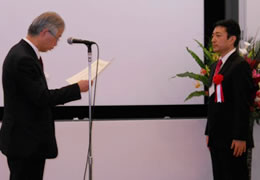 LCA日本フォーラムの山本会長（左）から表彰状を受け取る、東芝メディカルシステムズの東木技師長の写真