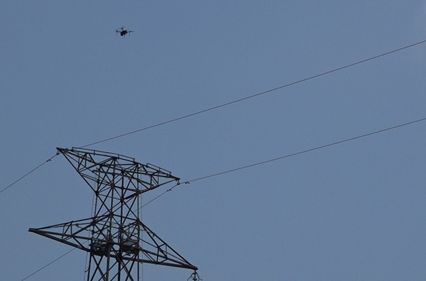 図2：関西電力 能力開発センターの訓練用の送電線の上空を自動飛行撮影するドローンの様子