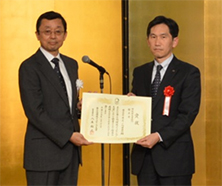 「審査委員長（左）と東芝小向事業所 瀧井所長（右）」の写真