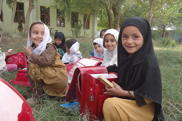 日本から届けられたランドセルを手にするアフガニスタンの子どもたち