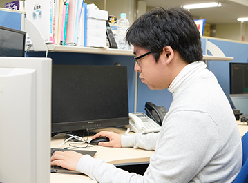 デスクに向かう橋本さんの写真